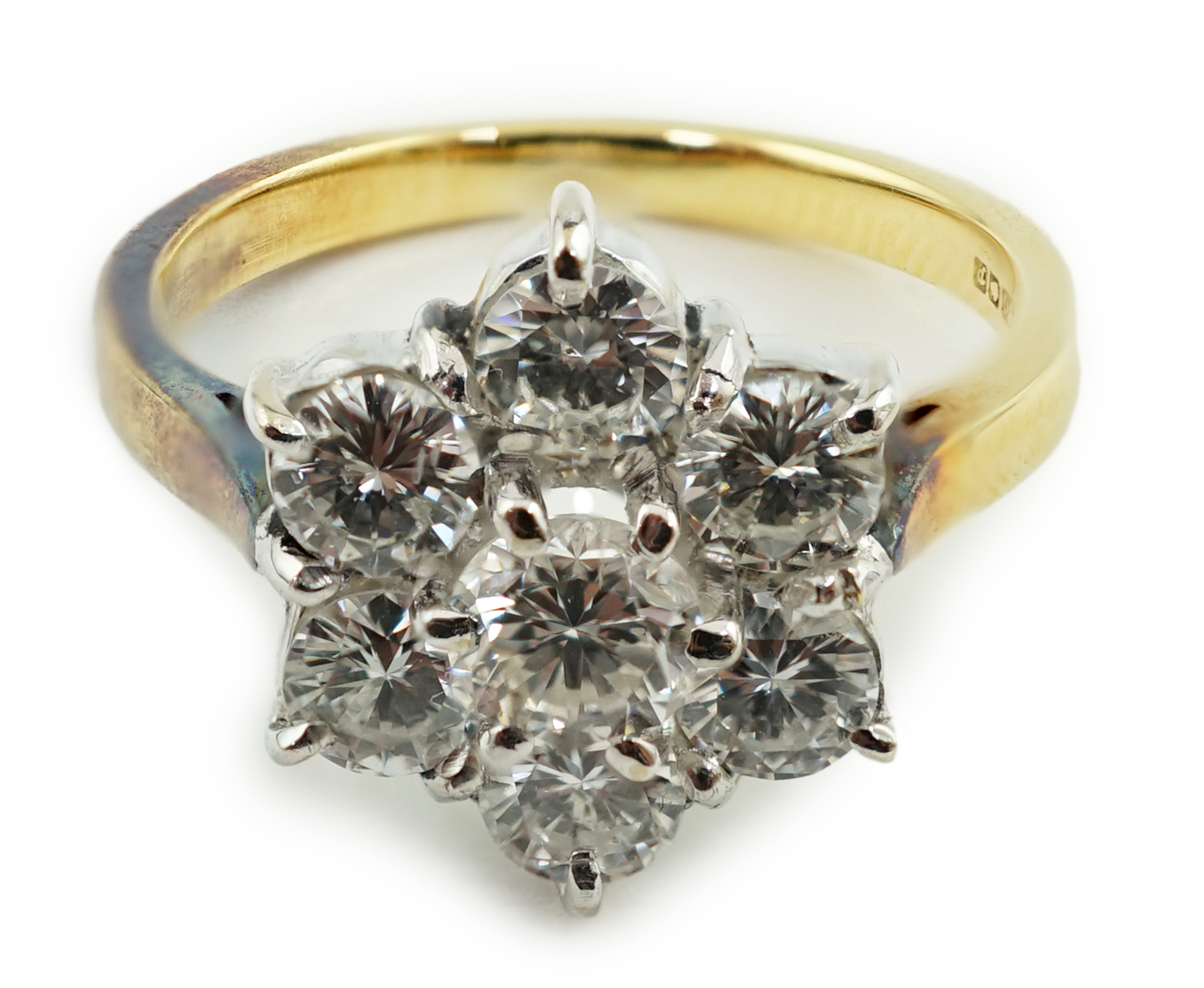 A modern 18ct gold and seven stone diamond set flower head cluster ring